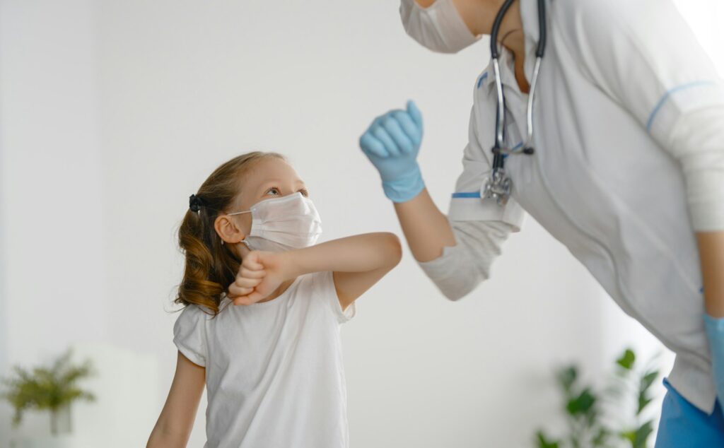 Doctor and child wearing facemasks