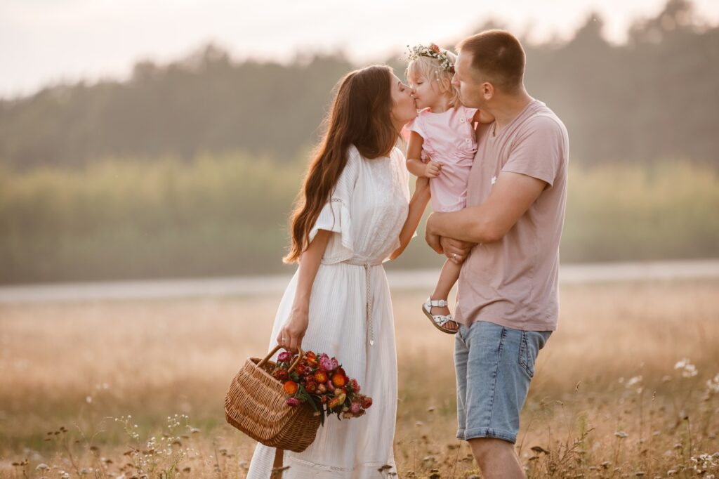 Portrait of happy family. Mom, dad and daughter walk in the field. Young family spending time